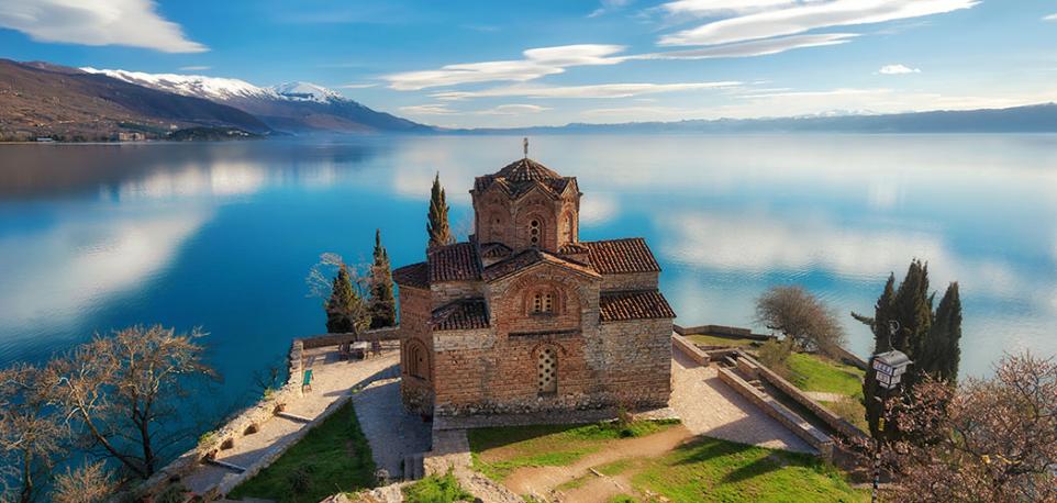 En esta foto se observa una pequeña iglesia cerca de un gran lago